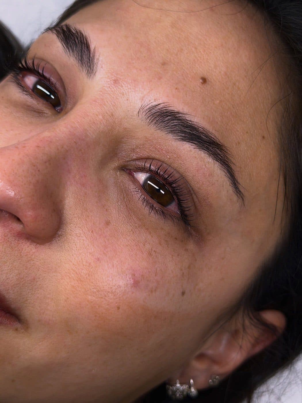 Rostro de clienta con cejas prolijas y piel luminosa